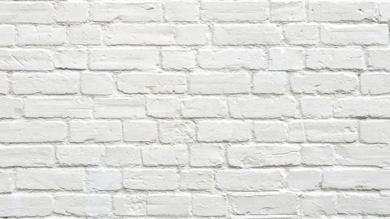 Pared de ladrillos blancos, con textura rugosa. Parece que se puede tirar una pared maestra, pero es solo una ilusión visual.