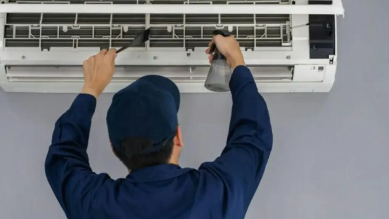 Técnico limpiando un aire acondicionado, paso clave para saber como montar aire acondicionado y mantenerlo.