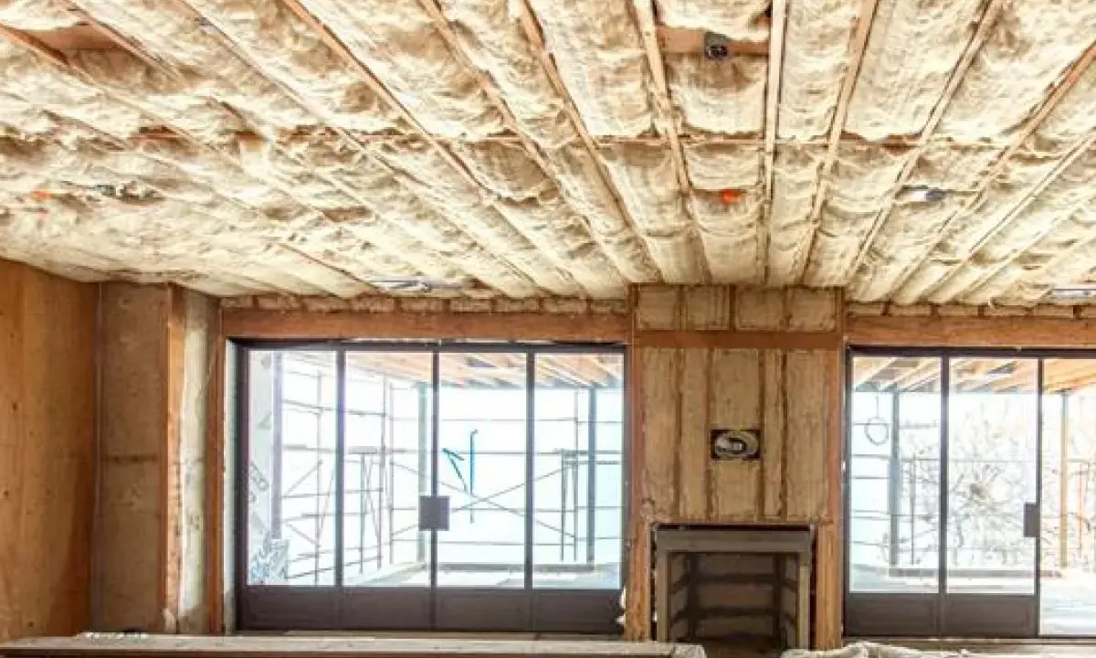 Techo con aislamiento de lana de vidrio, material que es inflamable. Ventanales y chimenea en construcción.