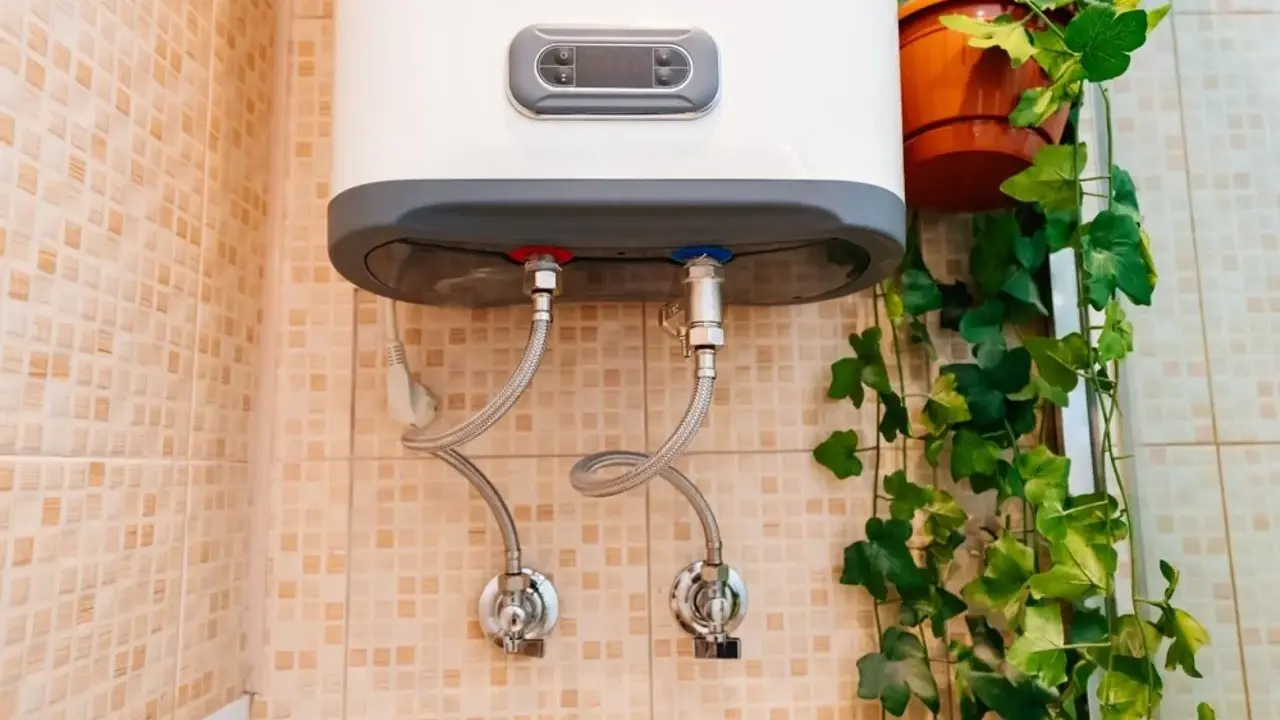 Termo eléctrico no sale agua caliente. Las tuberías de conexión y las válvulas están visibles en la pared con azulejos.