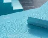 Planchas de poliestireno extruido (XPS) de color azul, apiladas y listas para aislamiento. El XPS es un material ligero y resistente.