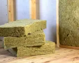 Bloques de lana mineral, un material aislante, apilados sobre madera. Así es que es la lana mineral.