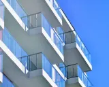 Balcones modernos de un edificio blanco con barandillas de cristal azul contra un cielo despejado. ¿Qué es el ITE?