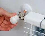 Mano ajustando la perilla de un radiador, mostrando partes de un radiador de agua como la válvula y la conexión.