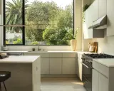 Cocina moderna con campana extractora de acero inoxidable. El motor de la campana extractora no funciona, pero la vista al jardín es espectacular.