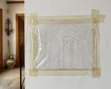 Plástico adherido a pared con cinta, mostrando gotas de condensación. Indica posibles humedades en el suelo de la planta baja.