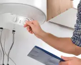 Técnico revisa termo eléctrico que no enciende piloto. Ajusta el control de temperatura.