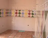 Detalle de azulejos en una pared, mostrando la diferencia entre mortero capa fina y capa gruesa en un diseño de rombos.