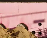 Aislamiento rosa para cimentación, con arena y tuberías. Su baja transmitancia térmica es clave para la eficiencia energética.