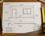 Planos de una habitación con medidas: vista frontal y superior, mostrando puerta, ventana, enchufe y rodapié. La profundidad edificable es de 60 cm.
