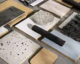 Muestras de materiales de construcción reciclados: piedra, madera, textiles y terrazzo.