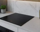 Placa de inducción negra moderna en encimera de granito. Considera los requisitos para instalar una placa de inducción para una cocina elegante.