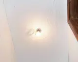 Techo con paneles de poliestireno extruido, una bombilla encendida y un marco de madera.