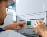 Técnico ajustando un calentador de gas butano. El esquema de instalación es complejo, pero él lo domina.