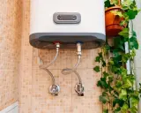 Termo eléctrico no sale agua caliente. Las tuberías de conexión y las válvulas están visibles en la pared con azulejos.