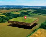 Un trozo de tierra flotante con un marcador de casa, listo para ser un fondo edificable en un paisaje rural.