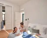 Pareja relajándose en la cama, con el aire acondicionado en modo noche creando un ambiente perfecto.