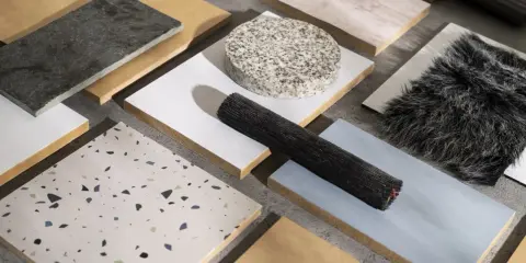 Muestras de materiales de construcción reciclados: piedra, madera, textiles y terrazzo.