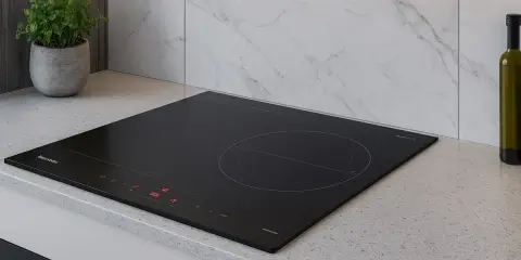 Placa de inducción negra moderna en encimera de granito. Considera los requisitos para instalar una placa de inducción para una cocina elegante.