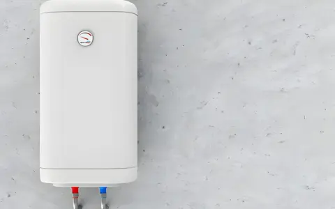 Termo eléctrico blanco colgado en pared de cemento. Las tuberías de agua fría y caliente indican que el termostato podría estar fallando porque salta el termostato del termo eléctrico.