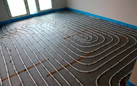 Instalación de tuberías para convertir suelo radiante en refrescante. El sistema de calefacción/refrigeración por suelo radiante se está instalando en un nuevo edificio.