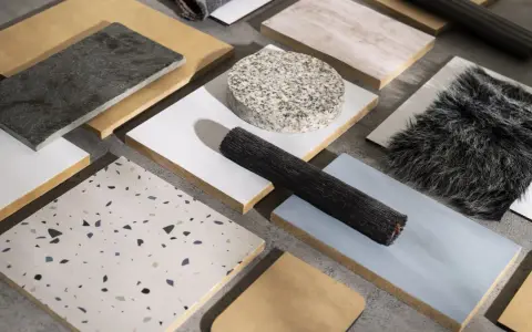 Muestras de materiales de construcción reciclados: piedra, madera, textiles y terrazzo.