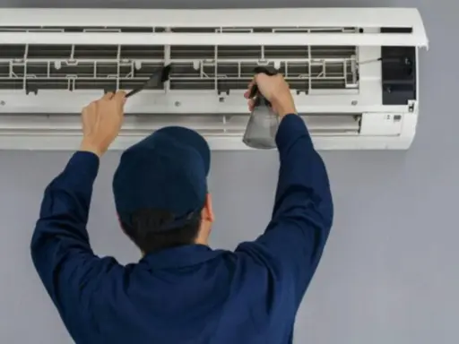 Técnico limpiando un aire acondicionado, paso clave para saber como montar aire acondicionado y mantenerlo.