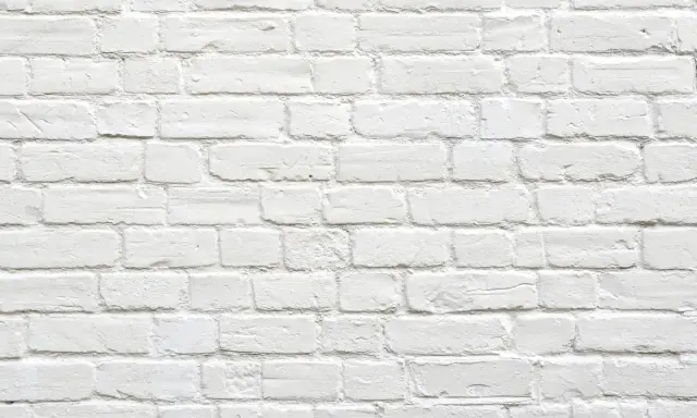 Pared de ladrillos blancos, con textura rugosa. Parece que se puede tirar una pared maestra, pero es solo una ilusión visual.