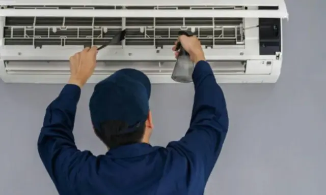 Técnico limpiando un aire acondicionado, paso clave para saber como montar aire acondicionado y mantenerlo.