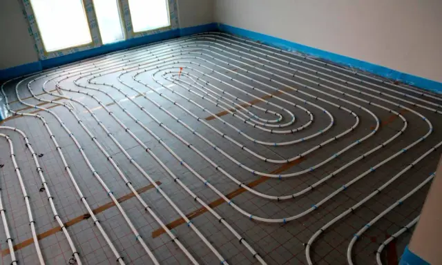 Instalación de tuberías para convertir suelo radiante en refrescante. El sistema de calefacción/refrigeración por suelo radiante se está instalando en un nuevo edificio.