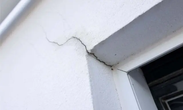 Grietas en pared blanca, indicando necesidad de mantenimiento sate.