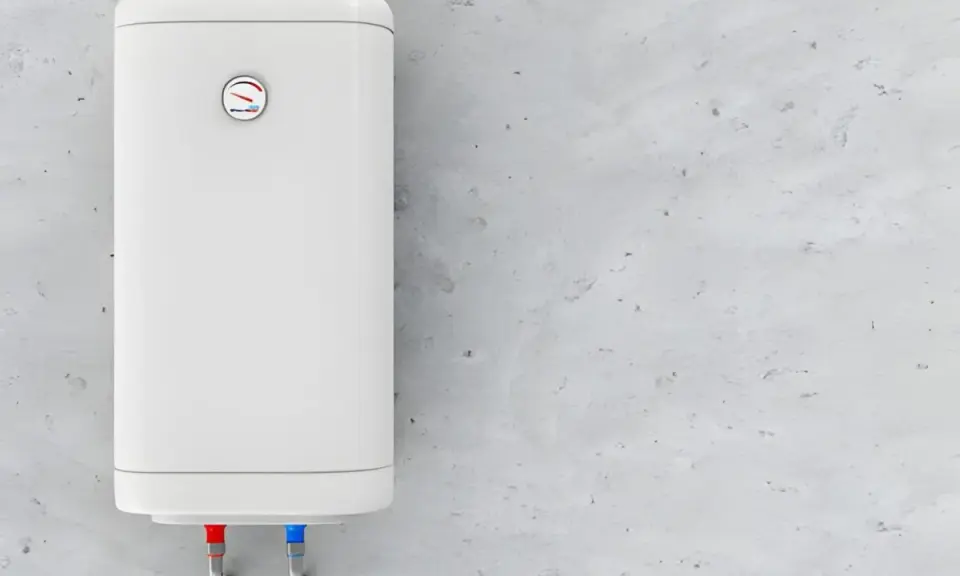 Termo eléctrico blanco colgado en pared de cemento. Las tuberías de agua fría y caliente indican que el termostato podría estar fallando porque salta el termostato del termo eléctrico.
