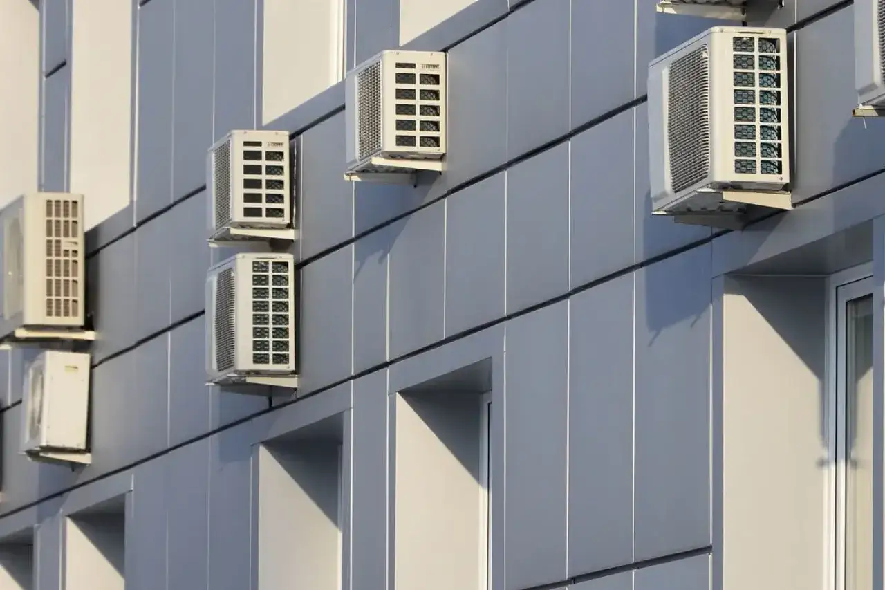 Unidades de aire acondicionado montadas en fachada gris. Cumplen la normativa de instalación de aire acondicionado.