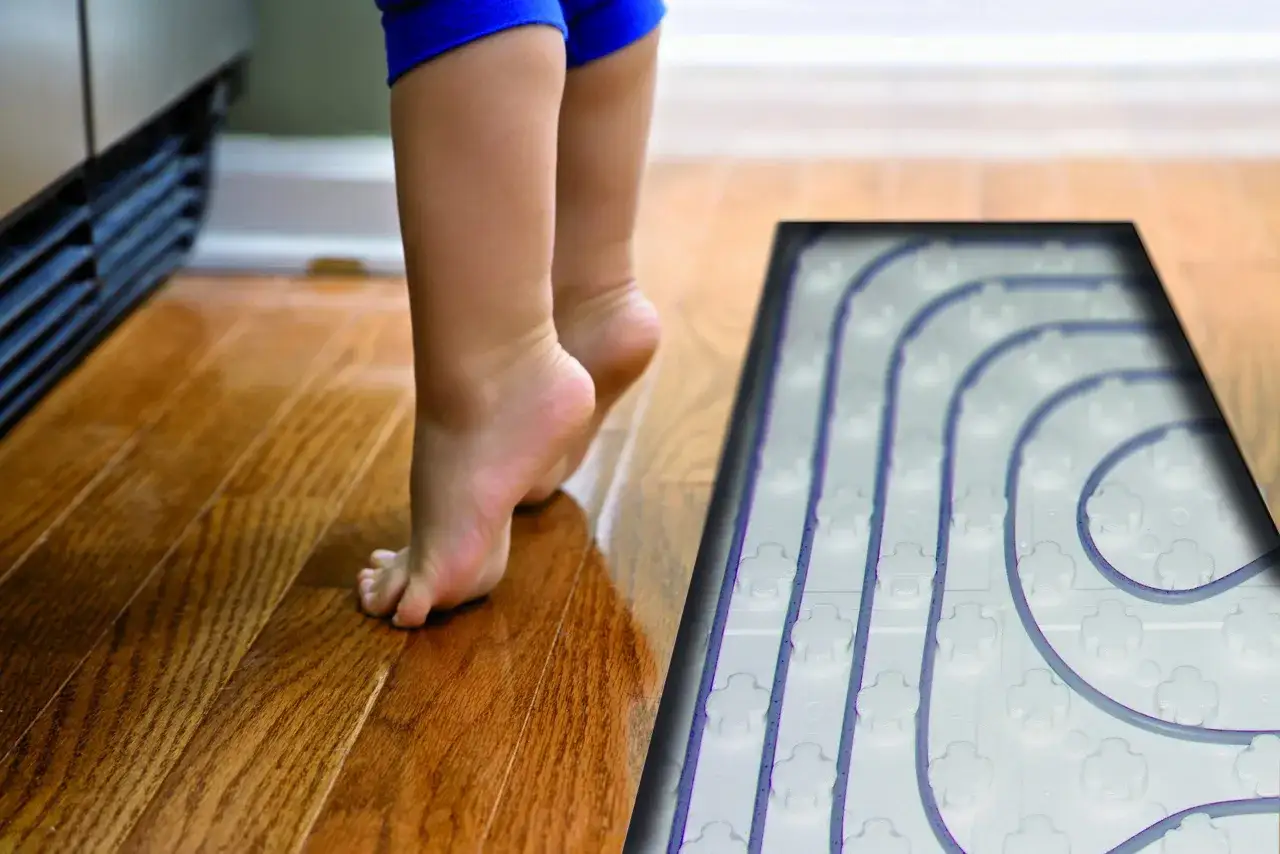 Niño descalzo sobre suelo de madera, mostrando el sistema de suelo radiante. La temperatura de impulsión de aerotermia en verano mantiene el hogar fresco.