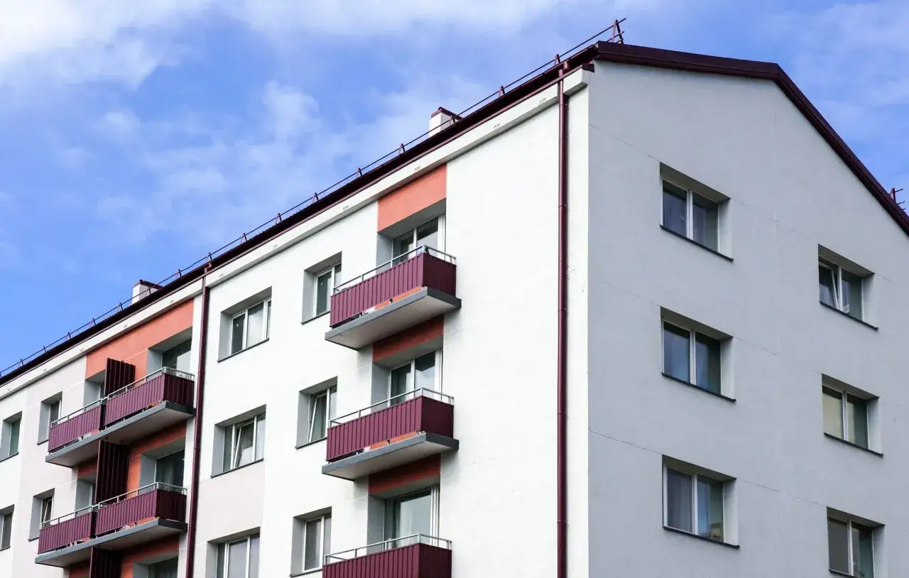 Edificio de apartamentos con balcones y ventanas, cumpliendo la normativa de aislamiento térmico en viviendas para eficiencia energética.