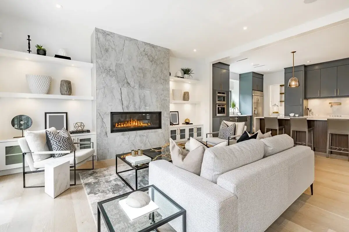Elegante sala con chimenea moderna de gas, un ejemplo de las clases de chimeneas que realzan el diseño. Cocina integrada al fondo.
