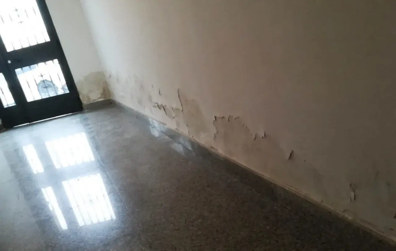Pintura descascarada en la pared de una habitación, indicando humedades en el suelo de la planta baja.