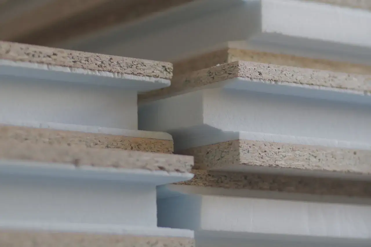 Capas de material compuesto, con un n&uacute;cleo blanco y bordes de aglomerado. El xps significado es un material aislante.