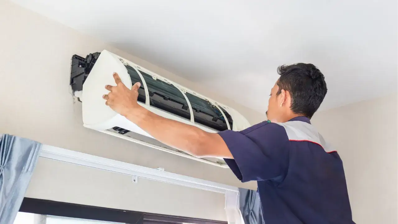 Técnico revisa un aire acondicionado con una avería.