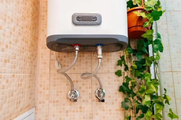 Termo eléctrico no sale agua caliente. Las tuberías de conexión y las válvulas están visibles en la pared con azulejos.